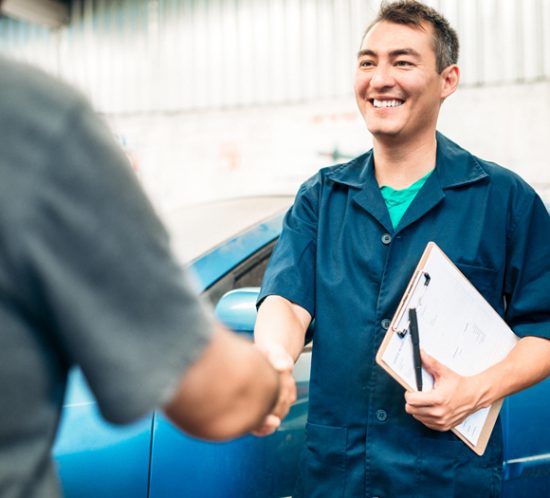 Two people shaking hands in a garage - Boyd Insurance