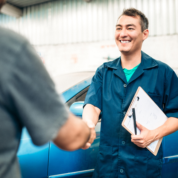 Two people shaking hands in a garage - Boyd Insurance