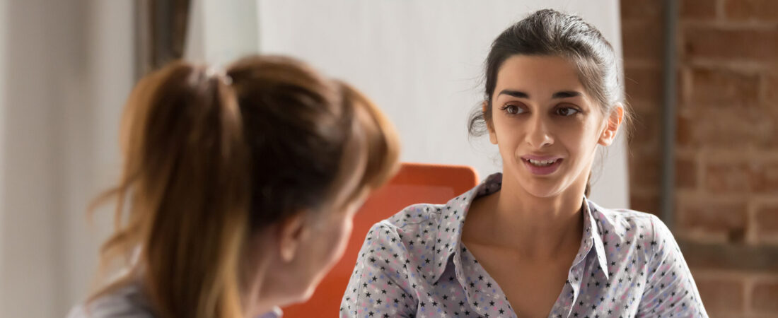 Indian businesswoman speaking to colleague or hr during job interview, young professional hindu woman manager consulting client or explaining giving advice teaching at business office meeting